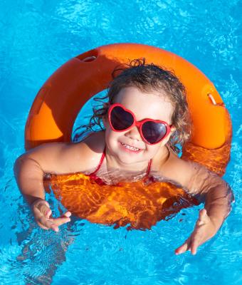 petite fille dans une piscine avec une bouée orange